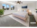Bright bedroom featuring a large bed, soft carpeting, and scenic views through the multiple windows at 2125 Stone Well Rd, North Las Vegas, NV 89031