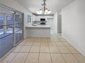 Open-concept dining room featuring tile floors and a view of the modern white kitchen at 2125 Stone Well Rd, North Las Vegas, NV 89031