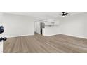 Open-concept living area with wood floors, white walls, and a modern ceiling fan at 2480 Old Forge Ln # 74, Las Vegas, NV 89121
