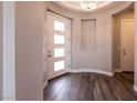 Bright foyer with a modern light fixture, hardwood flooring, and a contemporary door at 2680 Nevada Agave Ln, Las Vegas, NV 89138