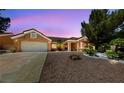 Single-story home featuring a low-maintenance desert landscape with a two-car garage at 2925 Lotus Hill Dr, Las Vegas, NV 89134