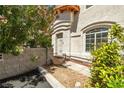 Inviting front entrance with a secure gate, desert landscaping, and a peek into the arched windows at 3464 Twilight Star Dr, Las Vegas, NV 89117