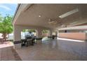 Spacious covered patio with ceiling fans, a grill, and access to the backyard, perfect for outdoor entertaining at 5204 Padua Way, Las Vegas, NV 89107