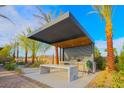 Outdoor kitchen featuring a marble countertop, built-in grill, and modern pergola in a landscaped backyard at 6110 Pebble Glen Ct, Las Vegas, NV 89149