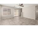 Spacious living room featuring tile floors, a ceiling fan, and stairs to the second floor at 6443 Burlap Ct, Las Vegas, NV 89122