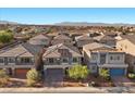 An aerial view showcasing a neighborhood of homes with mountain views in the distance at 6618 Tangled Vines Ave, Las Vegas, NV 89139