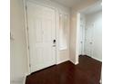 Bright entryway featuring a white front door, wood flooring, and a window with blinds at 6946 Motley Rd, Las Vegas, NV 89178