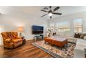 Inviting living room with a leather armchair, white sectional, leather ottomans, and a flat screen television at 715 Orange Plume Walk, Henderson, NV 89011
