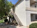 Condo exterior featuring stairs to the second floor and mature landscaping at 75 N Valle Verde Dr # 2121, Henderson, NV 89074