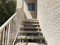 Close-up of exterior condo stairs with a white metal handrail at 75 N Valle Verde Dr # 2121, Henderson, NV 89074