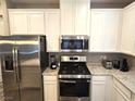 Bright kitchen featuring stainless steel appliances, white cabinets, granite countertops, and modern fixtures at 8534 Insignia Ave # 101, Las Vegas, NV 89178