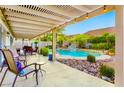 Covered patio overlooks the backyard pool, featuring desert landscaping at 8928 Rusty Rifle Ave, Las Vegas, NV 89143