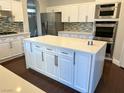 Bright kitchen features sleek stainless steel appliances, a spacious island and white cabinetry at 8931 Lansberry Ct, Las Vegas, NV 89147
