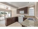 Well-lit kitchen featuring granite countertops, white appliances, and dark wood cabinets at 9305 Hollycrest Dr, Las Vegas, NV 89117