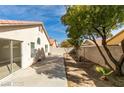 Spacious backyard featuring a covered patio, a retaining wall, and mature trees offering plenty of shade at 9378 Spellman Ct, Las Vegas, NV 89123
