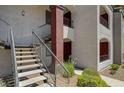 Exterior view of a modern condo featuring a staircase leading to upper-level units and red painted doors at 950 Seven Hills Dr # 1624, Henderson, NV 89052