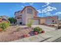 Home exterior showing a two-car garage, desert landscaping, and a red tile roof at 1025 Clover Tip Ct, Las Vegas, NV 89123