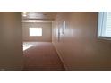 Long hallway with plush carpeting and ample natural light filtering through the windows at 10371 Calypso Cave St, Las Vegas, NV 89141