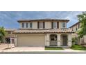 Charming two-story home with a tile roof, arched entryway, and manicured landscaping at 1069 Coronado Peak Ave, Las Vegas, NV 89183