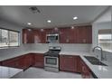 Modern kitchen with cherry wood cabinets, stainless steel appliances, and white quartz countertops at 1069 Coronado Peak Ave, Las Vegas, NV 89183