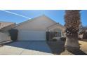 View of the home, driveway, and two-car garage with desert landscaping at 1325 Fiesta Grande Ct, North Las Vegas, NV 89031