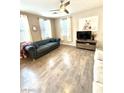 A cozy living room with hardwood floors, tufted sofa, and neutral-toned decor at 1355 Grass Creek Ave # 1, Henderson, NV 89012
