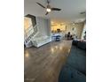 Open-concept living area with hardwood floors, staircase and view into kitchen at 1355 Grass Creek Ave # 1, Henderson, NV 89012