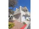 Exterior view of a townhome with a garage and well maintained landscaping at 2761 Lodestone Dr # 63, Las Vegas, NV 89117