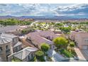 Aerial view of a home showcasing its backyard, neighboring houses, and mountain views at 2785 Rosenhearty Dr, Henderson, NV 89044
