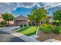 Well-maintained single-story home with a vibrant lawn, desert landscape, and convenient two-car garage at 2785 Rosenhearty Dr, Henderson, NV 89044