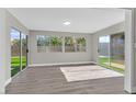 Bright sun room featuring gray wood floors, windows, and glass sliding doors to backyard at 3849 Boca Chica Ave, Las Vegas, NV 89120