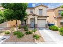 Charming two-story home with stucco exterior, a blue front door, desert landscaping, and attached garage at 4249 Fleet Dancer St, Las Vegas, NV 89129