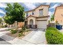 Charming two-story home with stucco exterior, a blue front door, desert landscaping, and attached garage at 4249 Fleet Dancer St, Las Vegas, NV 89129