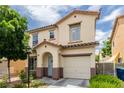 Charming two-story home with stucco exterior, a blue front door, desert landscaping, and attached garage at 4249 Fleet Dancer St, Las Vegas, NV 89129