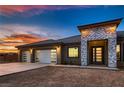 Close-up view of a house with a three-car garage and a modern entrance with beautiful brickwork at 4740 W Agate Ave, Las Vegas, NV 89139