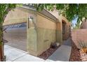 Side exterior showcasing a garage and walkway, surrounded by meticulous landscaping and greenery at 5452 Tinker Toy Ave, Las Vegas, NV 89139