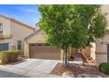 Charming home exterior with a well-maintained lawn, mature trees, and a two-car garage at 5452 Tinker Toy Ave, Las Vegas, NV 89139