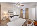 Comfortable carpeted main bedroom with a ceiling fan, window, and neutral decor at 6553 Baywood Ave, Las Vegas, NV 89103