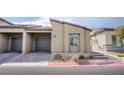 Modern exterior elevation with desert landscaping, brick driveway and gray two-car garage doors at 7517 Crested Moon St, North Las Vegas, NV 89084
