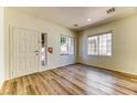 Bright living room with a front door, plank flooring, and plenty of light from the front windows at 7900 Dutch Canyon Ct, Las Vegas, NV 89131