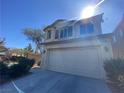 Home featuring a two-car garage, neutral colors, and desert landscaping at 8566 Bright Bush St, Las Vegas, NV 89131