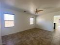 Bright living room featuring tile flooring, ceiling fan, and two large windows at 8566 Bright Bush St, Las Vegas, NV 89131