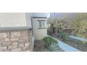 Side yard of home with stone accent wall and desert landscaping at 8695 Canfield Canyon Ave, Las Vegas, NV 89178