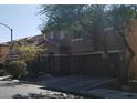 Two-story home featuring an attached garage, well-kept lawn, and welcoming curb appeal at 8749 Brilliant Star Dr, Las Vegas, NV 89178