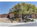 Beautiful single-story home featuring desert landscaping, stone accents, and mature trees at 9120 Parkstone Ave, Las Vegas, NV 89178