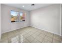 Cozy bedroom with neutral walls, tile flooring, base molding, and sun-filled windows at 9609 Rolling Thunder Ave, Las Vegas, NV 89148
