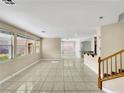 Open-concept living room featuring tile floors, recessed lighting, and multiple windows for ample natural light at 9609 Rolling Thunder Ave, Las Vegas, NV 89148