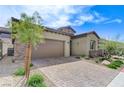 Desert home exterior features a brick driveway, a two-car garage, and desert landscaping at , Henderson, NV 89011