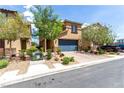 Beautiful two-story home with a blue garage door, landscaped front yard, and a brick driveway at 10086 Adina Ct, Las Vegas, NV 89141