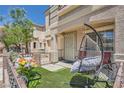 Delightful front porch with comfortable seating, artificial turf, and decorative flower boxes at 10456 Prairie Schooner Ave, Las Vegas, NV 89129